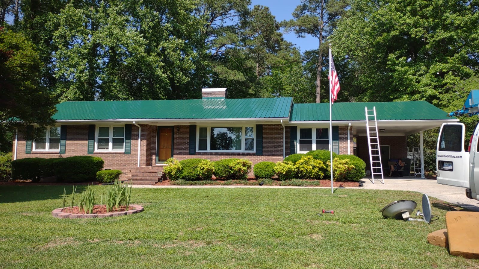 A green metal roof was installed on a residential property by Gator Metal Roofing.